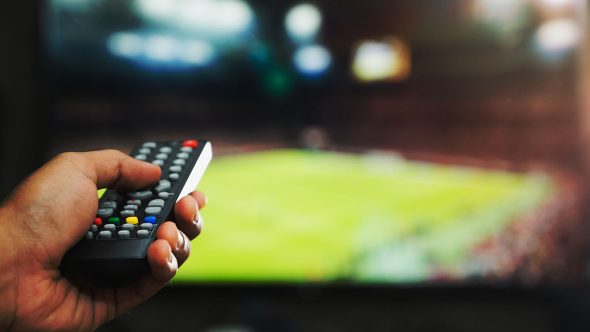 how_to_watch_football_on_tv_remote_pointing_at_screen.jpg